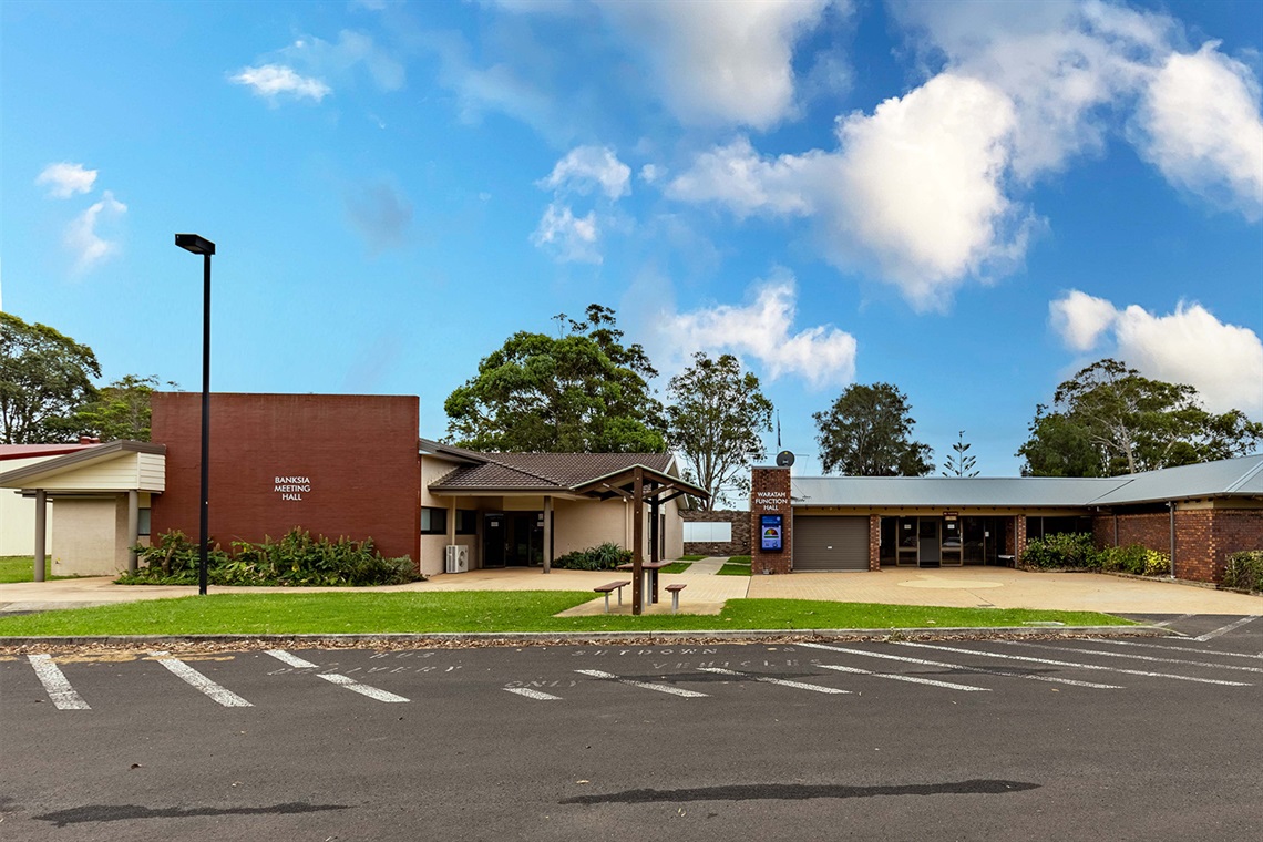 The Culburra Beach Community Centre. The Banksia Meeting Hall is on the left and the Waratah Function is on the right. There is a sheltered picnic bench out the front, and a community information hub under the waratah sign.