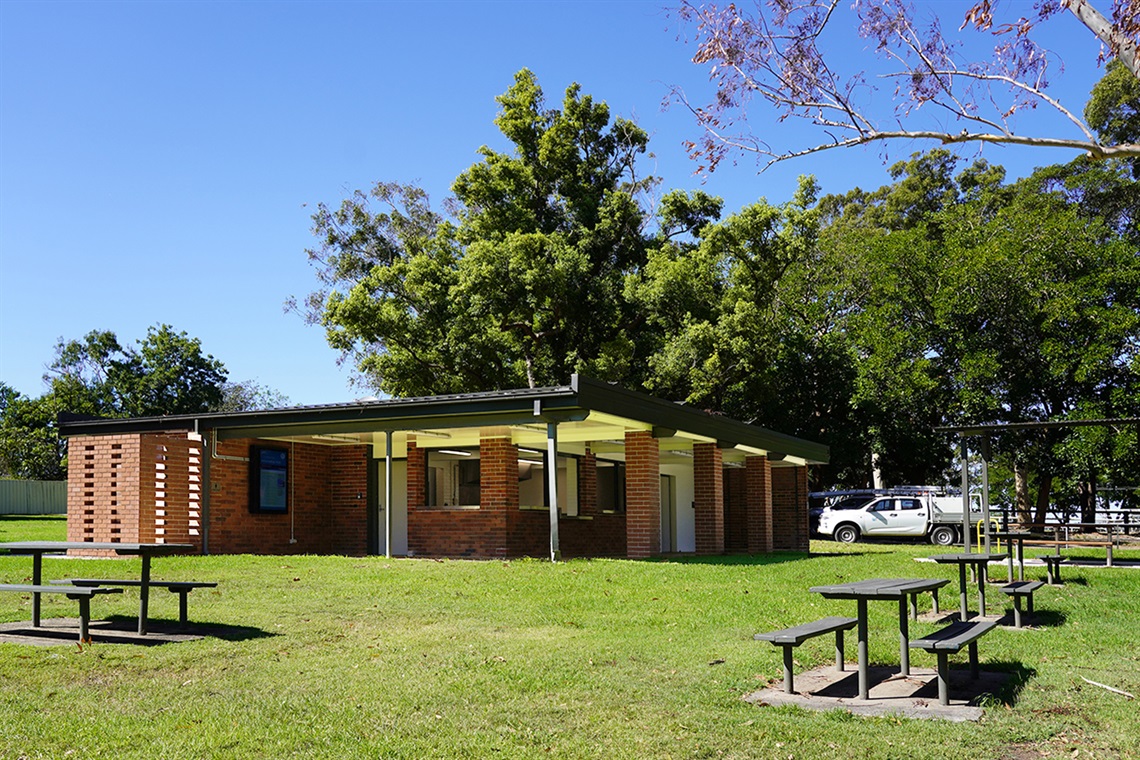 Front and side view of Family Café building surrounded by picnic tables and bench seating.
