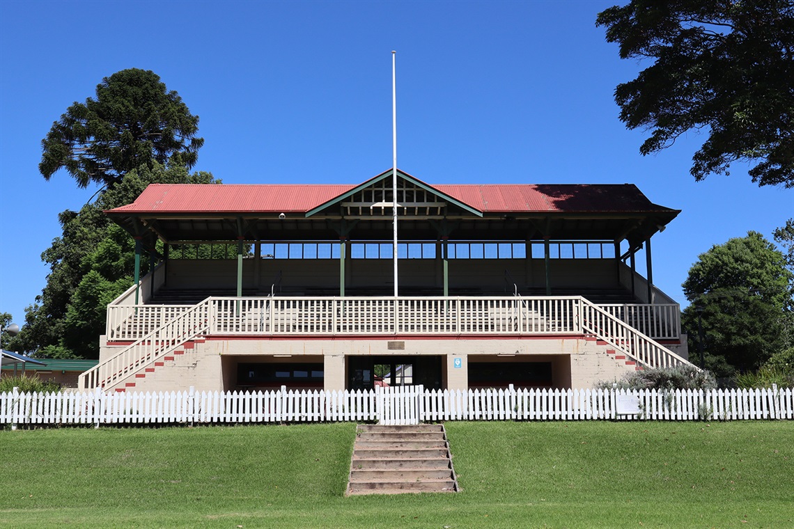 The grandstand at the Berry showground. There is a white picket fence separating the grandstand from the Main arena, and the doors to the grandstand cafe are visible underneath the seating area.