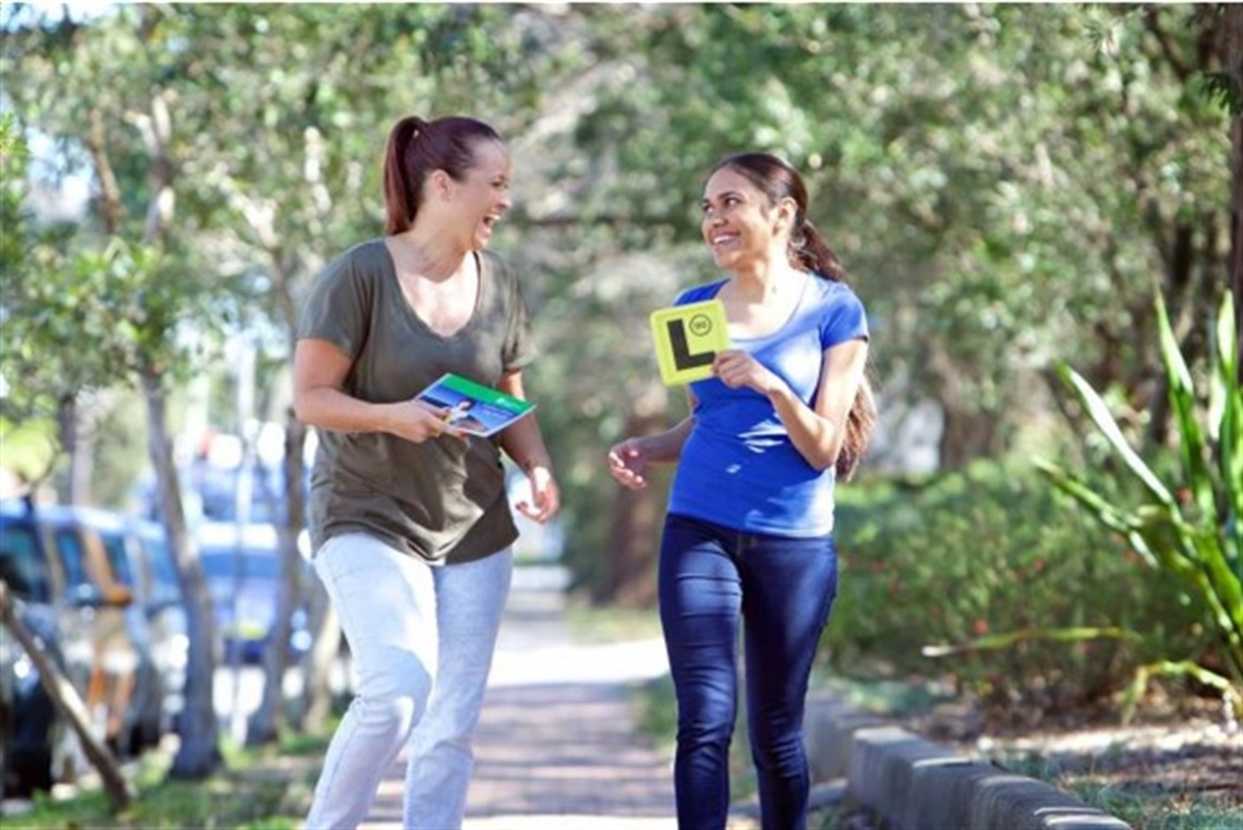 Mother and daughter with L plates and log book.