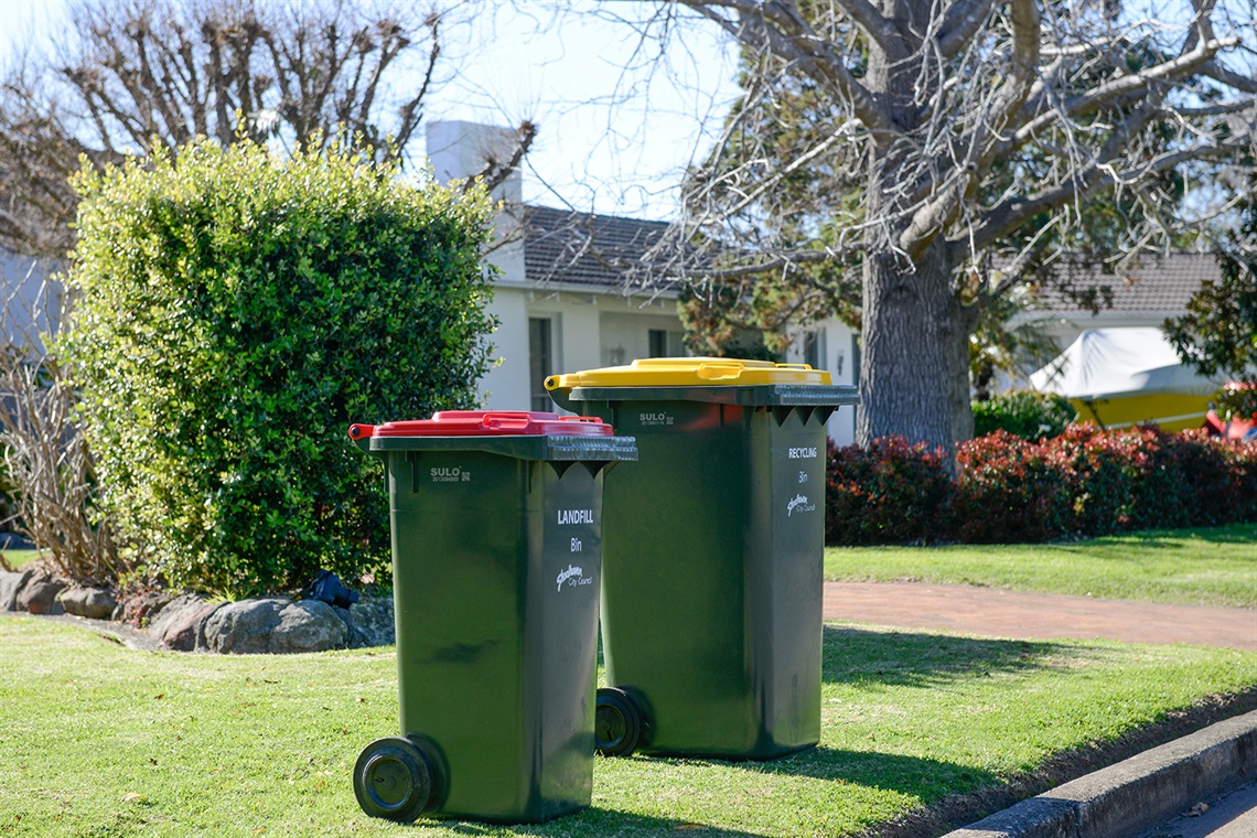 Red and yellow lid kerbside bins ready for collection