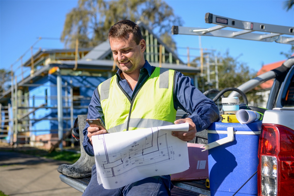 Builder looking at plans on worksite