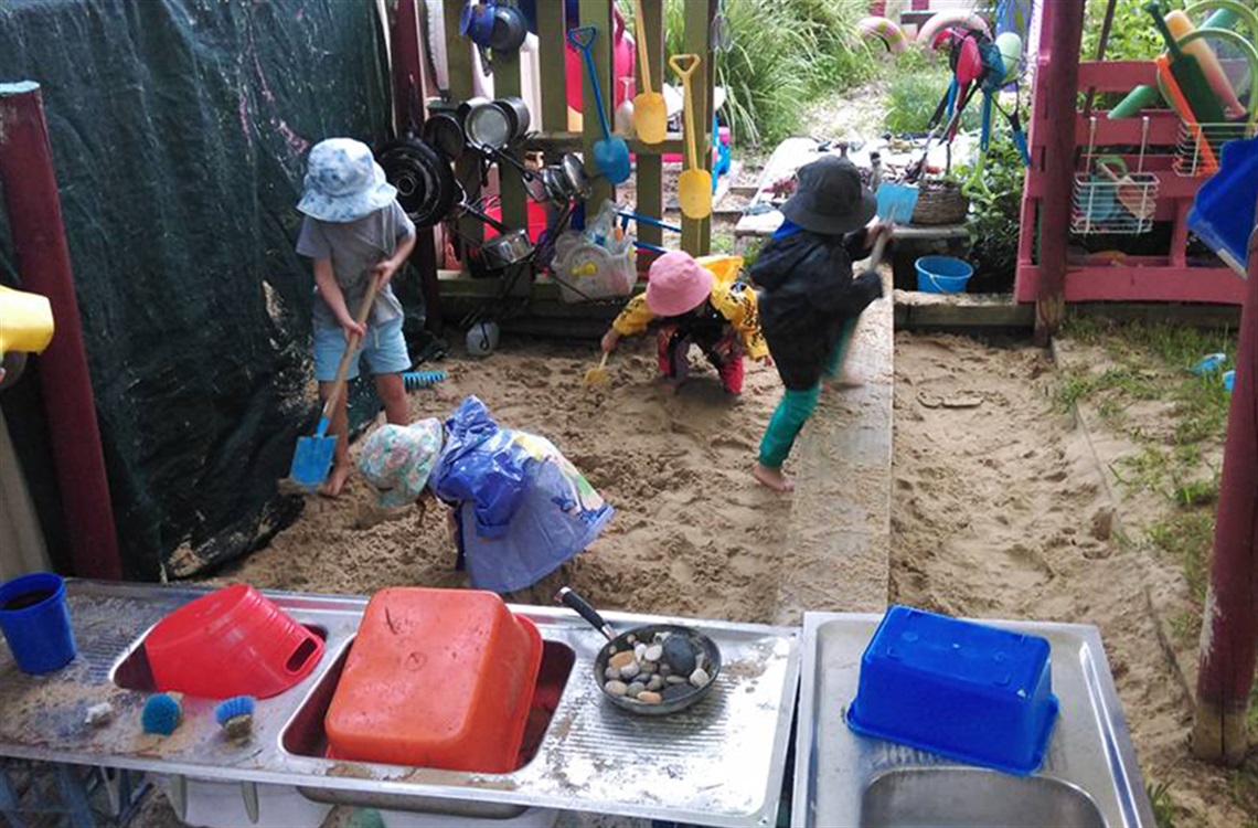 Young children digging in sandbox at Daycare