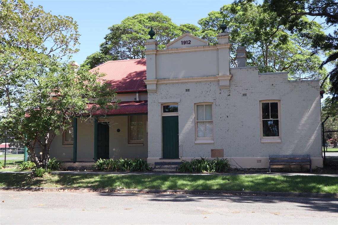 The Old Council Chambers at Berry Showground. The building is a historic building with a bullnose verandah. The facade of the building has a date plaque on the top that reads '1912'.  