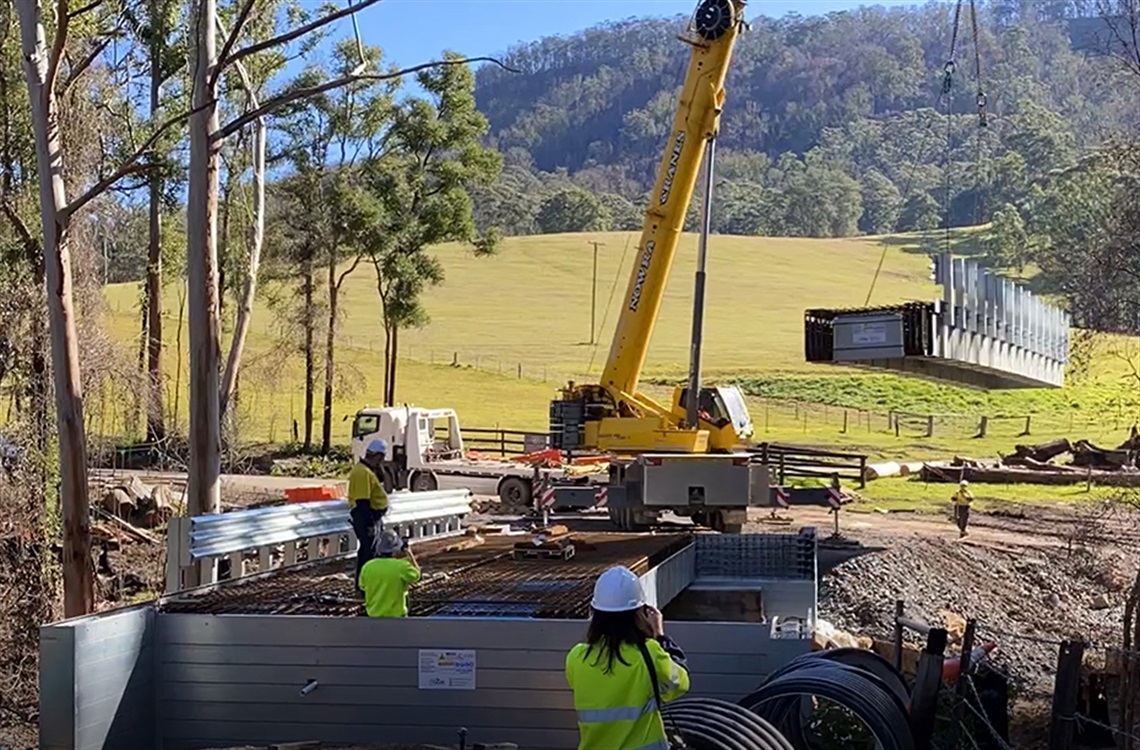 Crane lifting bridge segment into place