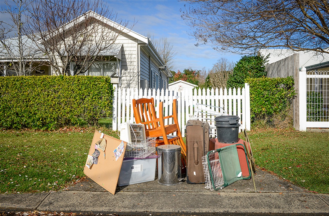 Bulky household items arranged neatly on driveway for pickup
