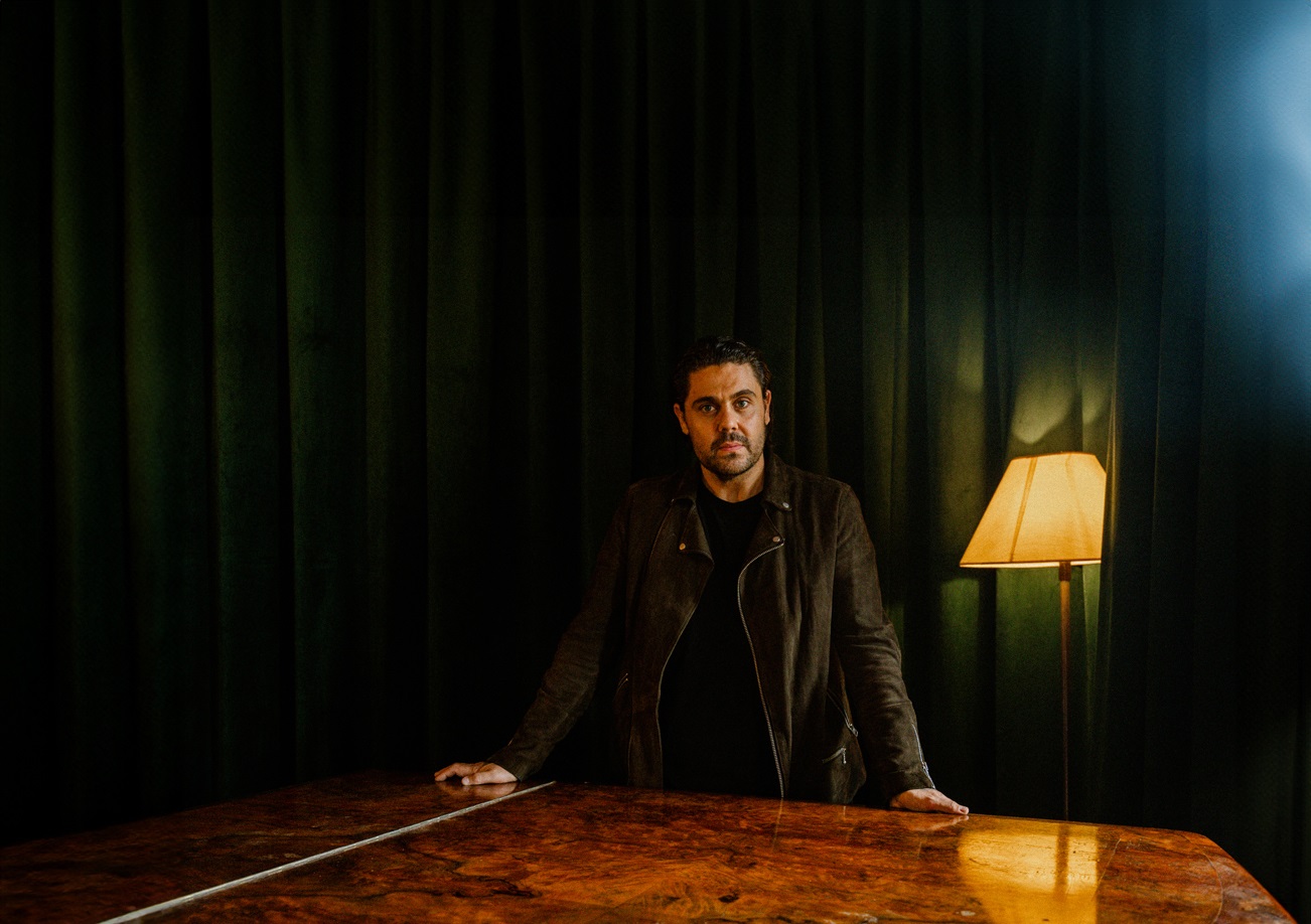 Photo of musician Dan Sultan in a low-light lounge setting.